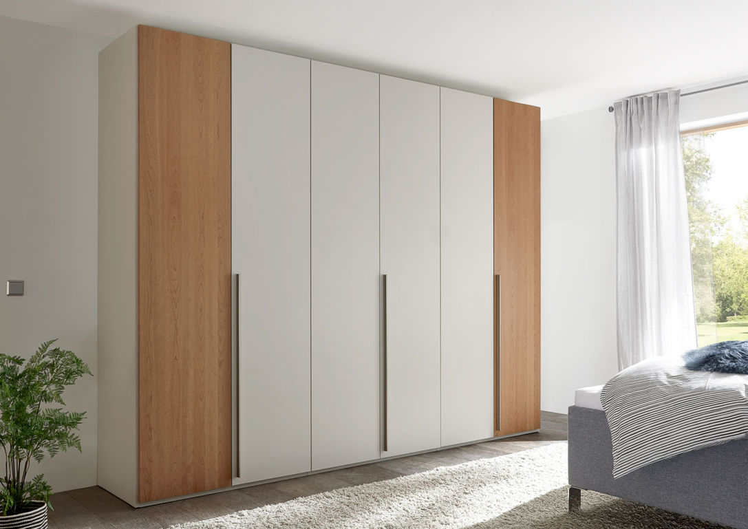 Loddenkemper L1000 — большой шкаф с белыми фасадами и деревянными боковыми панелями в светлой спальне