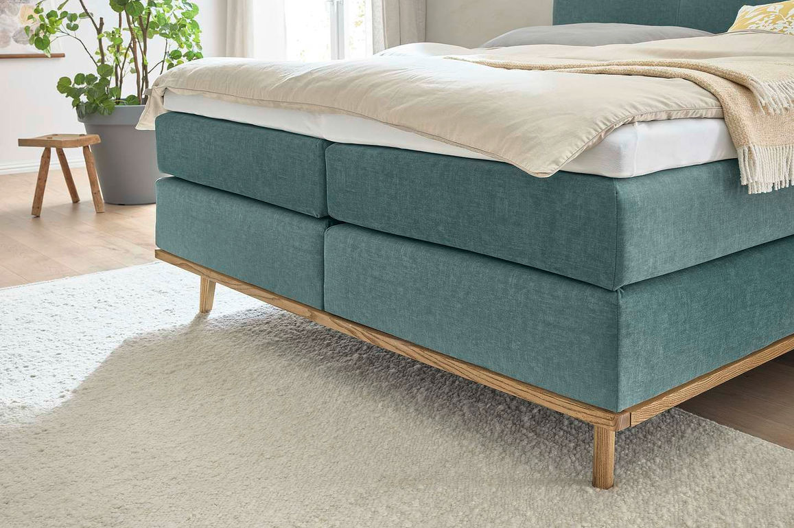 Boxspring — бирюзовая кровать на деревянном каркасе в светлой спальне